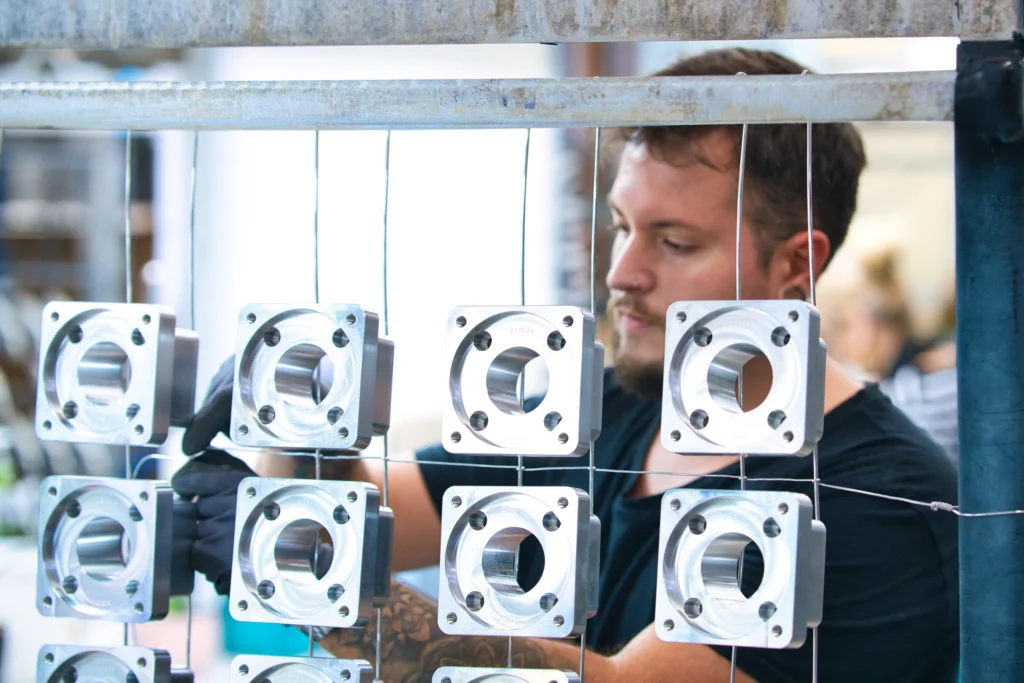 Qualitätsprüfung nach der Oberflächenveredelung Mitarbeiter kontrolliert elektropolierte Metallbauteile