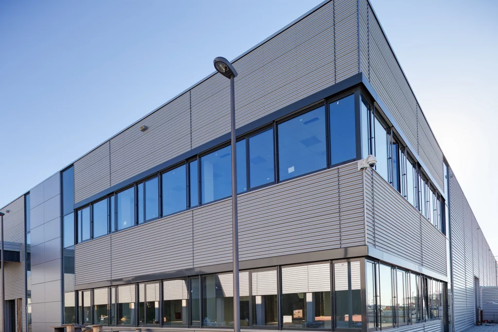 Aluminiumbeschichtete Fassade im Industriebau Moderne Industriegebäudefassade mit beschichteten Aluminiumprofilen zur Erhöhung von Witterungsschutz und Designqualität