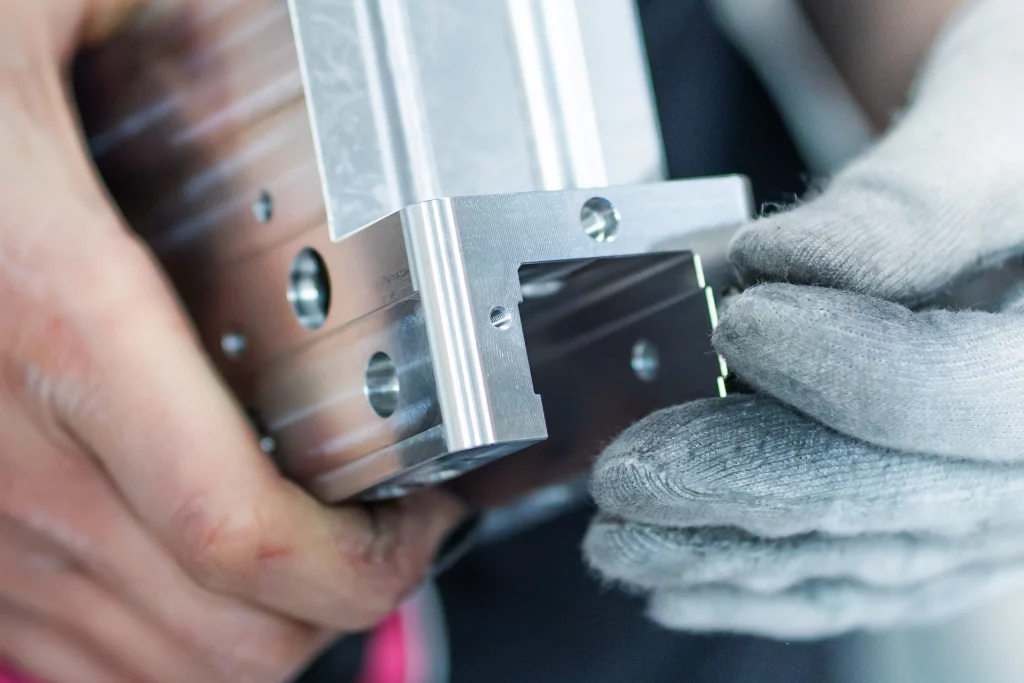 Oberflächenkontrolle eines Aluminiumbauteils Nahaufnahme eines präzise bearbeiteten Aluminiumbauteils bei der visuellen Kontrolle der Oberfläche